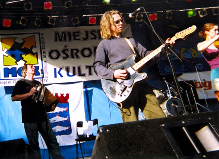 Andy, Dave and Anna on stage in the sun in Poland